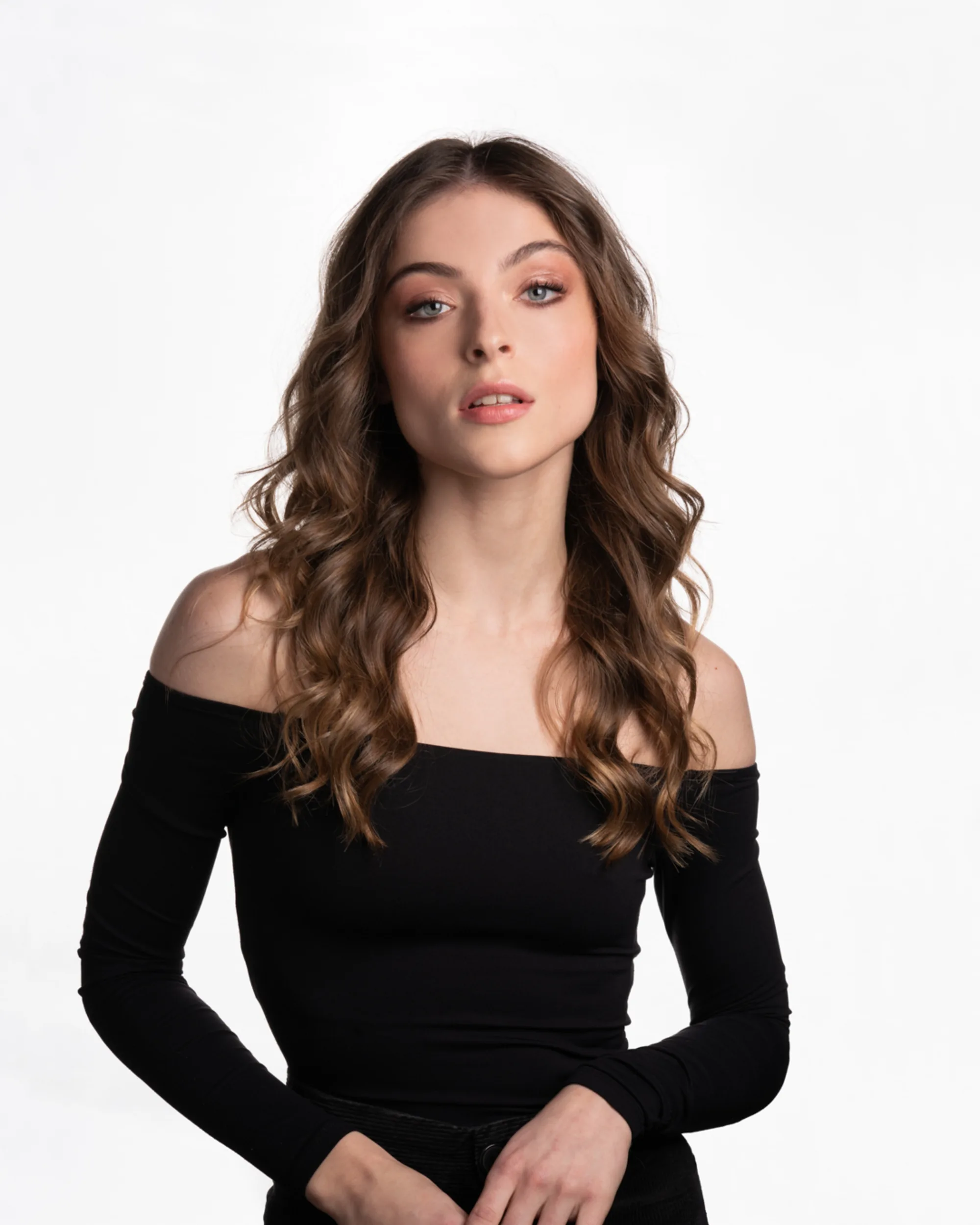 Portrait d'une cliente aux cheveux bruns ondulés, coiffée au salon