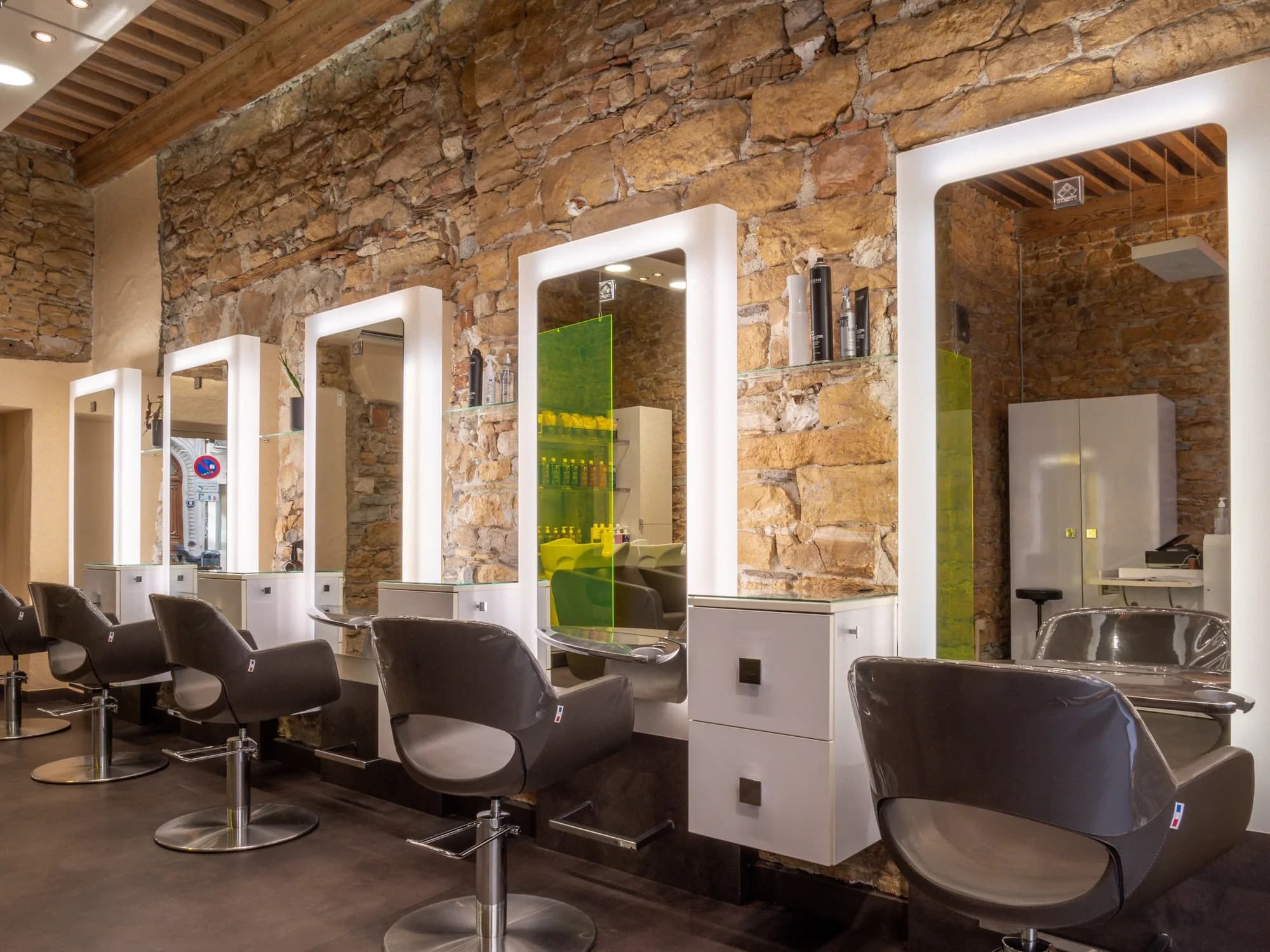 Postes de coiffage du Salon Bo, murs en pierre dorée et miroirs éclairés, rue de la Charité à Lyon